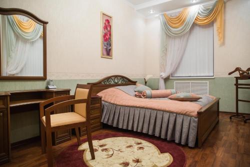 奥廖尔奥尔约酒店的一间卧室配有一张床、一张桌子和一把椅子