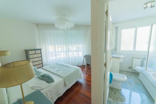 庞特维德拉HyP - LA CASA DE LAS HORTENSIAS的一间白色卧室,配有床和一间浴室