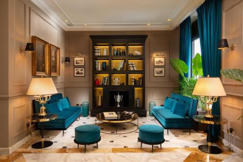 罗马Condotti Boutique Hotel的客厅设有蓝色的沙发和书架