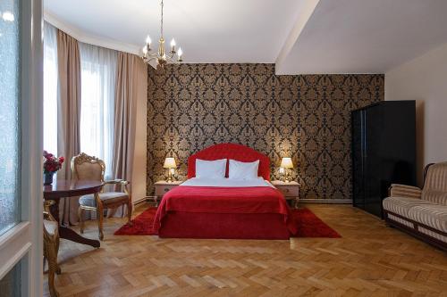 布拉索夫蒙特沃德之家旅馆的一间卧室配有红色的床和桌椅