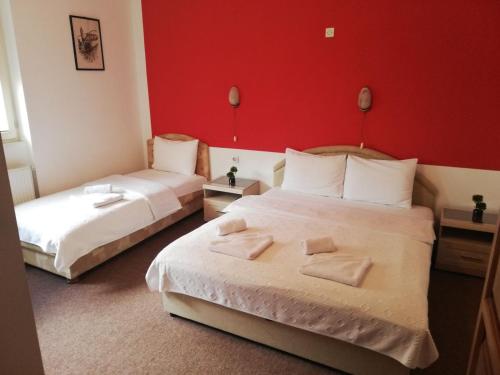 科拉欣里希希克客房酒店的红色墙壁的酒店客房内的两张床
