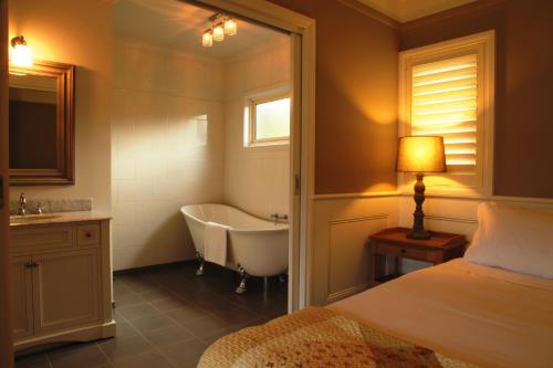 马里斯维尔马里斯维尔花园小屋酒店的一间带床、浴缸和水槽的浴室