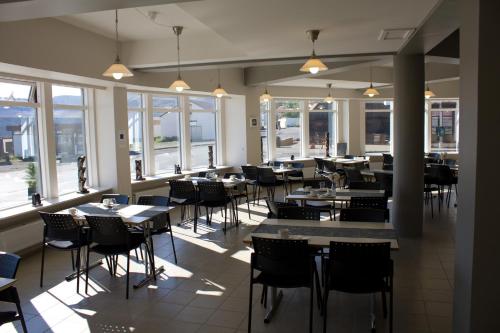 Þingeyri桑达菲尔酒店的用餐室设有桌椅和窗户。