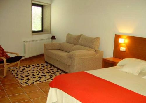 TouroCasa de campo a 10 min. de Santiago的客厅配有床和沙发