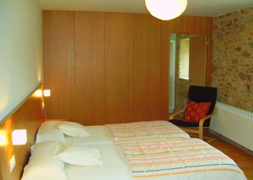 TouroCasa de campo a 10 min. de Santiago的一间卧室配有一张大床和一把椅子