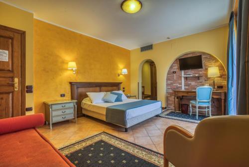 坎波巴索圣乔吉欧酒店的一间卧室配有一张床、一张书桌和一台电视。