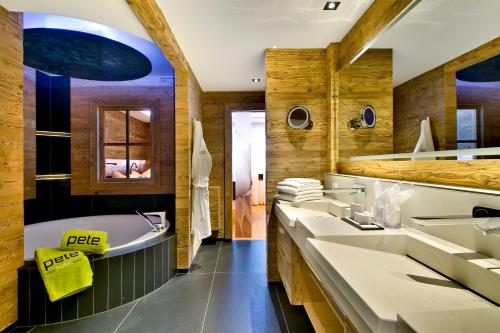 圣安东阿尔贝格PETE - Alpine Boutique Hotel的浴室配有3个盥洗盆、浴缸和浴缸。