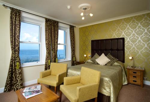 伊斯特布恩伊斯特本朗廷酒店的一间卧室配有一张床和两把椅子