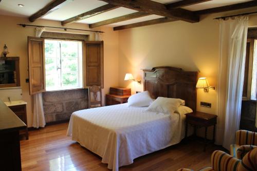 Coles卡萨格兰德迪苏图罗酒店的一间卧室配有一张带白色床单的床和一扇窗户。