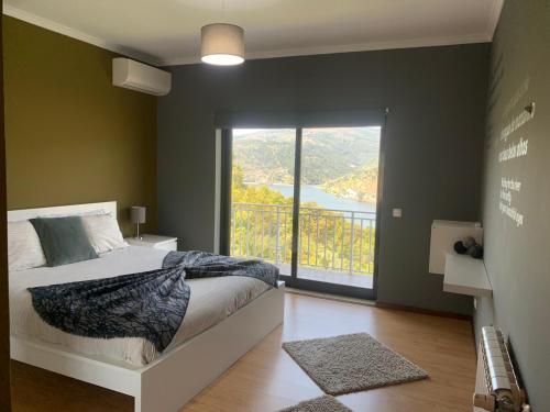 卡尔达斯德阿雷戈斯Douro Nest Houses的一间卧室设有一张床和一个大窗户