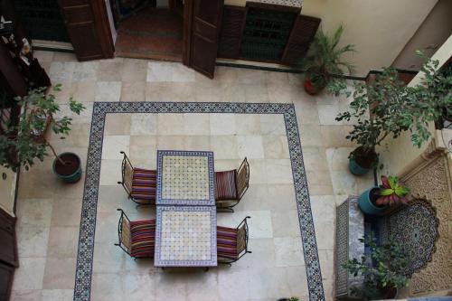 拉巴特达尔阿依达酒店的瓷砖地板上方配有桌椅的景色