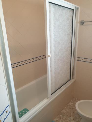 纳扎雷HOMELIDAYS CLARA NAZARE的浴室里设有玻璃门淋浴