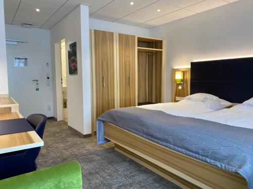 奥尔登堡Hotel Wieting的一间卧室配有一张大床和一张书桌