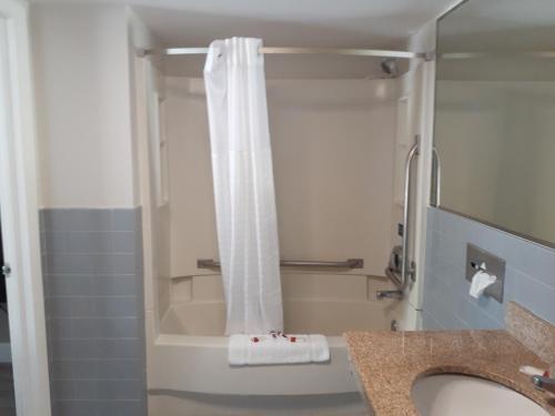 弗吉尼亚海滩旅行者湾海滩酒店的一间带白色淋浴帘的浴室
