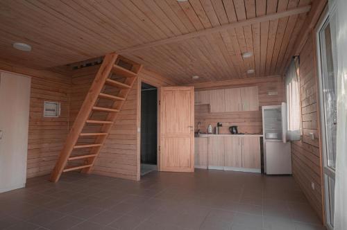 PaserninkaiVėjo Malūnų sodyba的厨房设有木制天花板和梯子