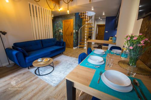 维斯瓦Apartamenty "Kwiaty Nocy" i "W Krainie Mchu" - Wisła的客厅配有蓝色的沙发和桌子