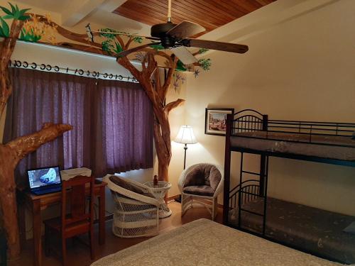 纽沃阿雷纳尔Marita's Bed and Breakfast的卧室的角落里有一棵树