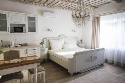 小瓦尔道BAB-LAK Apartman的白色卧室配有一张床和一个吊灯