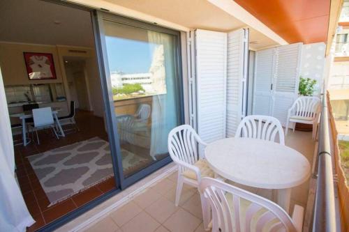阿尔布费拉Vacations home Albufeira的阳台配有白色的桌椅。