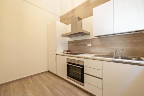特拉帕尼Aria di Mare Apartments的小厨房配有白色橱柜和水槽
