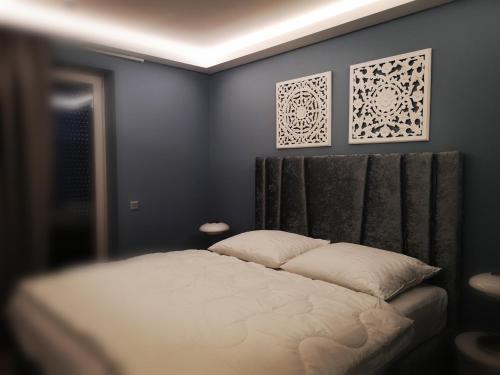 巴拉顿菲兹弗Fűzliget Mangó Terrace的卧室配有一张床,墙上挂有两张照片