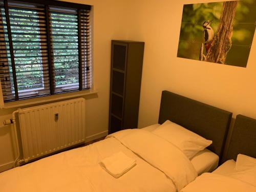 奥特罗Bonte Specht: tot rust komen in de natuur!的一间卧室设有一张床和一个窗口