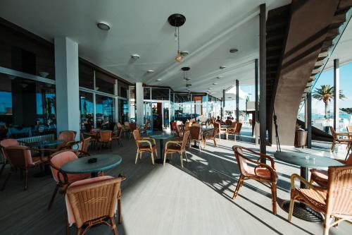 诺瓦利娅the Loža - seaside festival hotel的餐厅设有桌椅和窗户。
