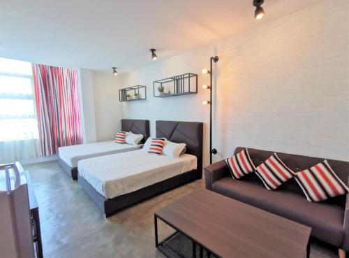麻坡MWV Suite Room (MUAR)的酒店客房,设有两张床和一张沙发