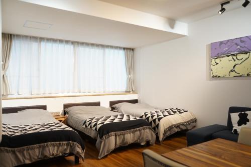 滨松Culinary Bed&Art2 403的带窗户的客房内的两张床