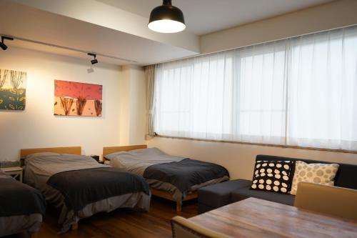 滨松Culinary Bed&Art 404的客房设有两张床、一张桌子和一扇窗户。