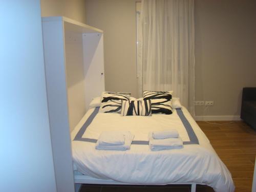 桑坦德Apartamentos LA PEREDA SANTANDER的房间里的一张床位,上面有两条毛巾