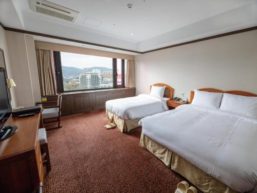 庆州庆州K酒店的酒店客房设有两张床和大窗户。