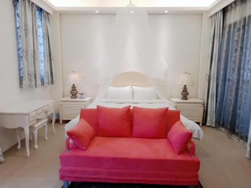 台中市一中太陽綠墅的卧室在床前配有红色沙发