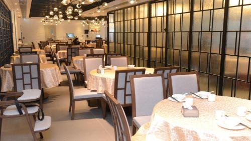 香港香港铜锣湾智选假日酒店的用餐室配有桌椅和吊灯。