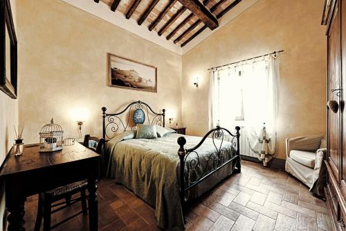 皮恩扎卡萨利诺乡村民宿的一间卧室配有一张床、一张书桌和一个窗户。