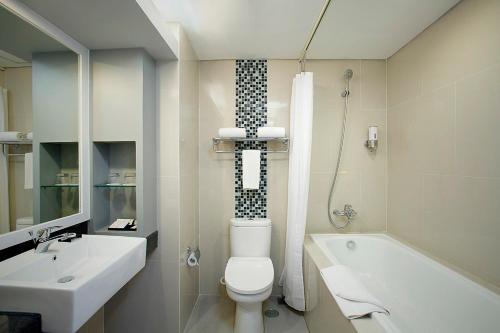 加拉旺BATIQA Hotel & Apartments Karawang的浴室配有卫生间、盥洗盆和浴缸。