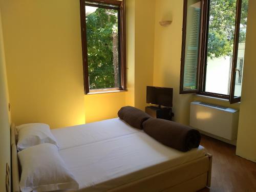罗马Villa Luzzatti的卧室配有一张白色大床和两个窗户