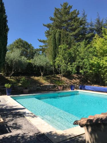 梅内尔伯Le mas jasmins的一座树木繁茂的庭院内的游泳池