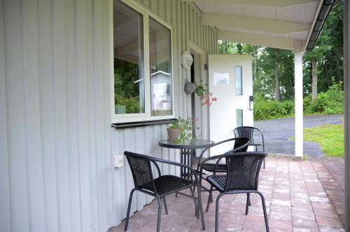 阿灵索斯Alingsås Golfklubb的门廊上配有四把椅子和一张桌子的庭院