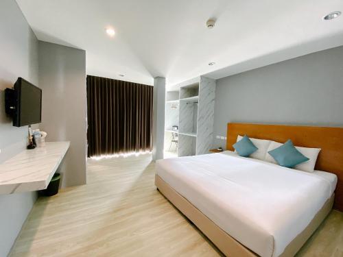 查汶苏梅岛场景俱乐部酒店的卧室配有带蓝色枕头的大型白色床