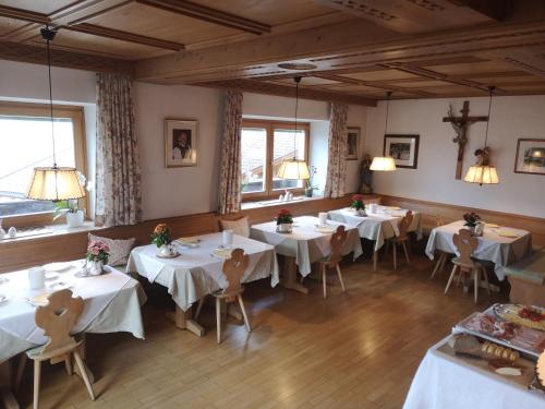 思科纳Active B&B Prairerhof的餐厅设有白色的桌椅和窗户。