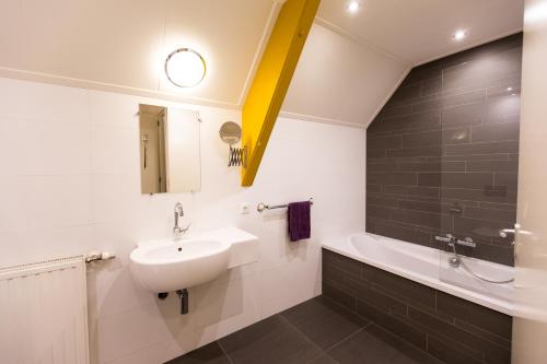 罗登Cuisinerie Mensinge With Dreams的浴室配有盥洗盆和浴缸。