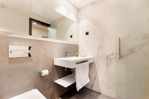 巴塞罗那隆达大厦酒店的白色的浴室设有水槽和淋浴。