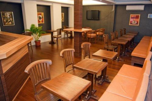 雅加达Hotel Rumah Shinta的用餐室配有木桌和椅子