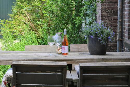 吉耶敦Het Doktershuys的木桌旁的一瓶葡萄酒和两杯酒