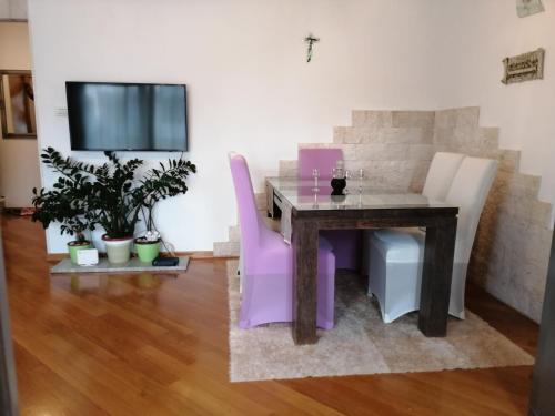 斯普利特维索卡公寓的一间带桌子和紫色椅子的用餐室