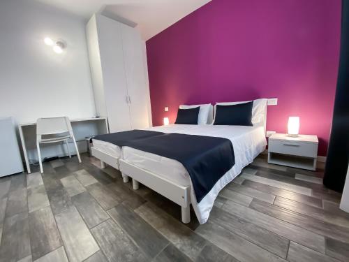 阿佐诺圣保罗Bonne Nuit Guest House的一间卧室配有一张大床和紫色墙壁