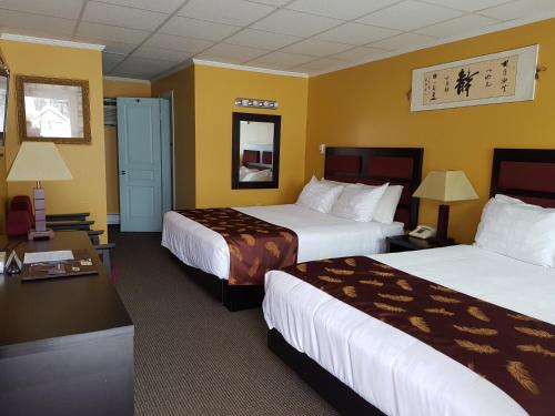 雷夫尔斯托克高山套房酒店的两张床位于带黄色墙壁的酒店客房