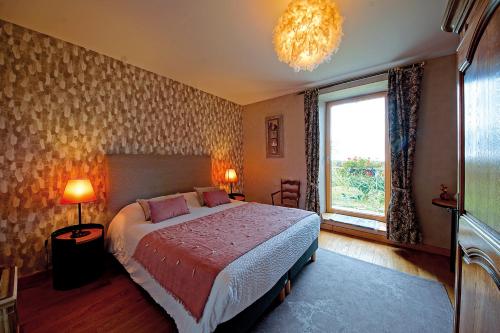孔卡尔诺Maison de Kersalomon的一间卧室设有一张床、一个窗户和一个吊灯。