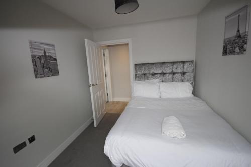 西德雷顿Holden Court Apartment 5的一间卧室配有一张带白色床单的大床